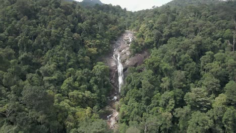 Water-cascades-down-steep-granite-wall-in-tropical-Air-Terjun-jungle