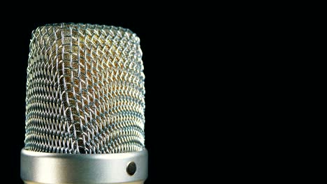 micrófono condensador de estudio gira sobre un fondo negro