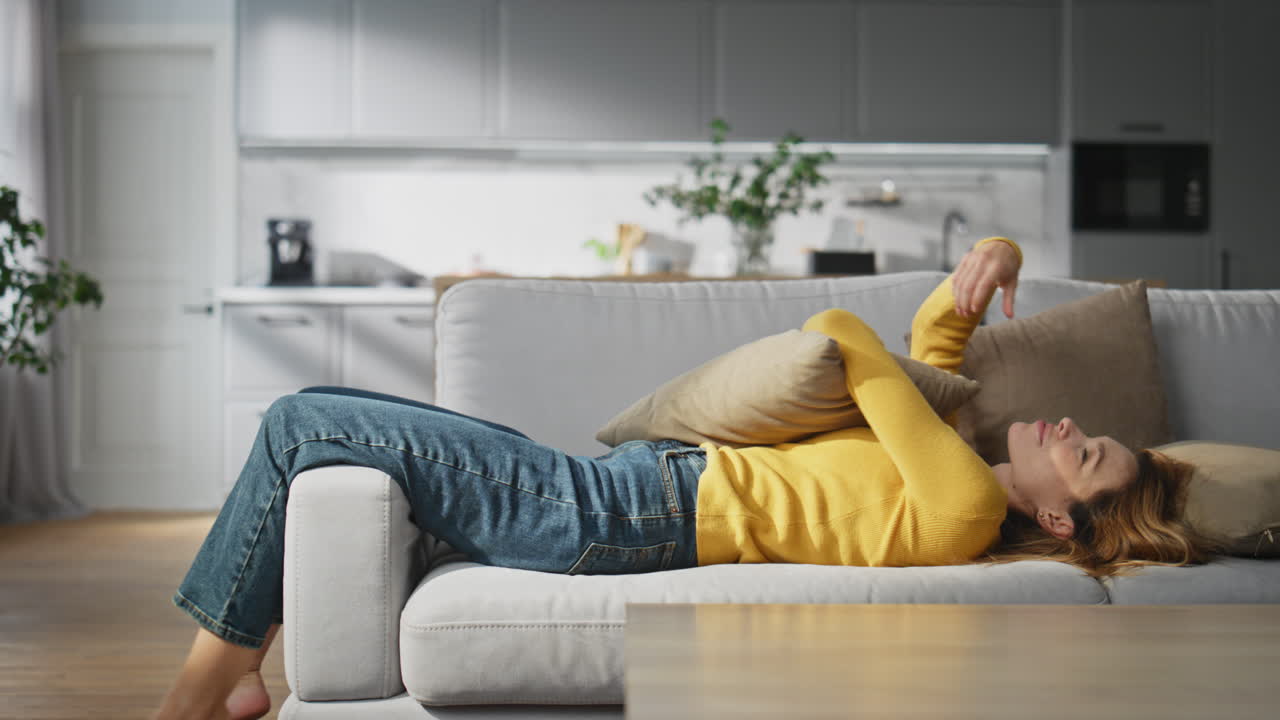 Romantic woman falling coach embracing pillow. Smiling girl feeling carefree