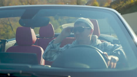 hombre conduciendo un coche convertible en una ruta panorámica
