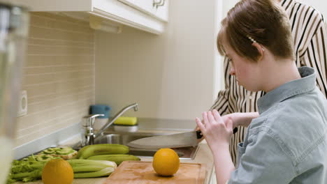 mère et fille coupant une orange dans la cuisine