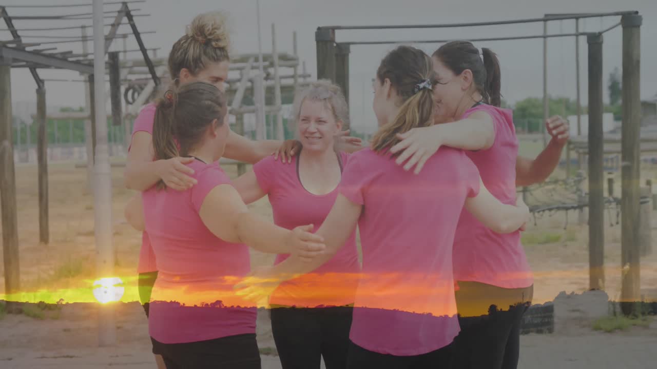 animación de la puesta de sol sobre diversas mujeres en una carrera de obstáculos abrazando.