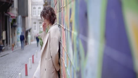 woman in beige coat on a colorful street