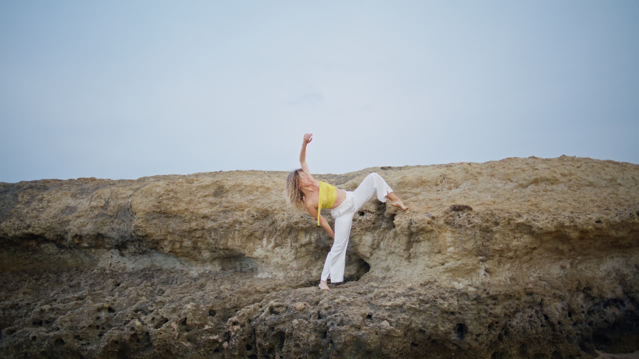 bailarina de estilo libre realizando una danza en rocas de piedra. hermosa mujer doblando el cuerpo