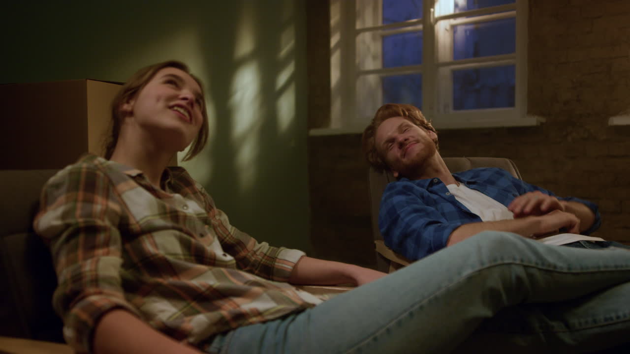 기쁜 커플이 집 안에서 집 수리를 논의하고 가족이 새로운 아파트에서 휴식을 취하고 있습니다.