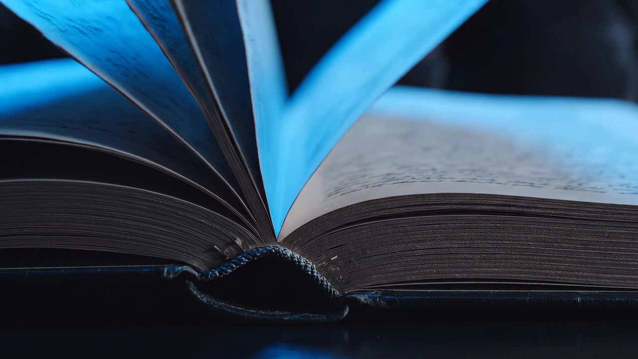 Close Up View of an Open Book Under Blue Light