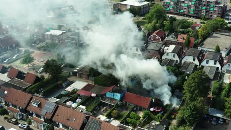 Toma-Aérea-De-Un-Incendio-En-Un-Cobertizo-Holandés-Ubicado-En-Un-Vecindario