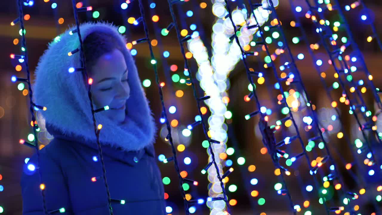 красивая девушка наслаждается ярким рождественским освещением