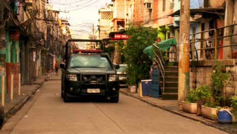 black truck with police in the back patrols the favela looking for drug gangs