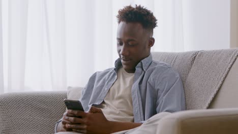 hombre usando teléfono inteligente en el sofá