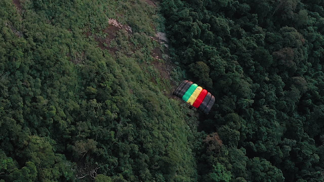vista aérea de un parapente que se desliza sobre un bosque verde y exuberante en río de janeiro