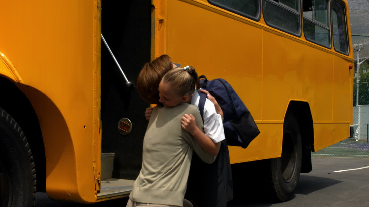 Mor sætter sin lille pige af ved skolebussen