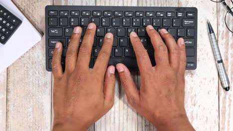 primer plano de las manos escribiendo en un teclado en un escritorio
