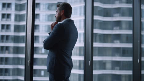 successful businessman looking out window