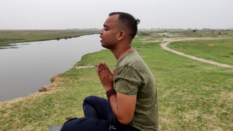 side view of an asian boy praying and meditating sitting down in lotus position