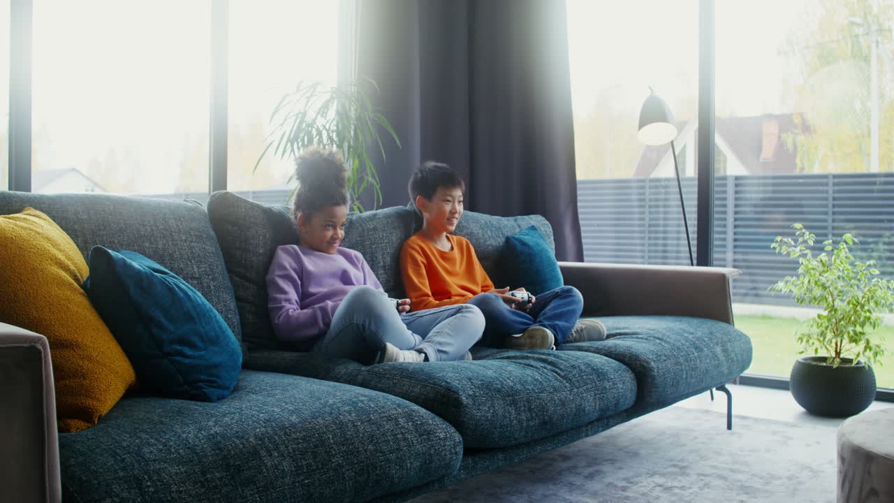 Children playing video games on the couch