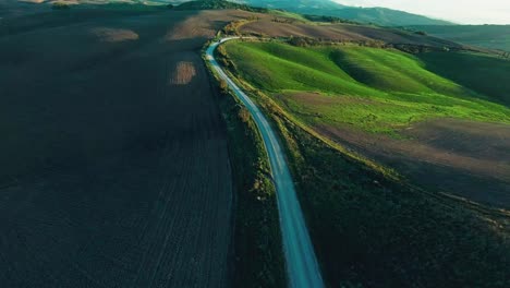 drone vuela sobre una carretera rural durante la puesta de sol cerca de pienza en la toscana, italia