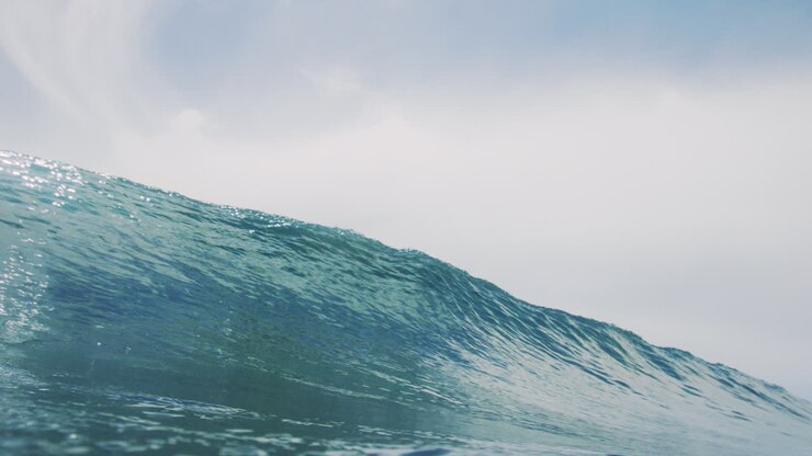 Glistening ocean water from sunlight crashes into clear barrel with perfect clarity
