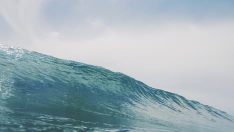 glistening ocean water from sunlight crashes into clear barrel with perfect clarity