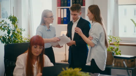 Businesswoman-discussing-strategy-with-coworkers-in-office.