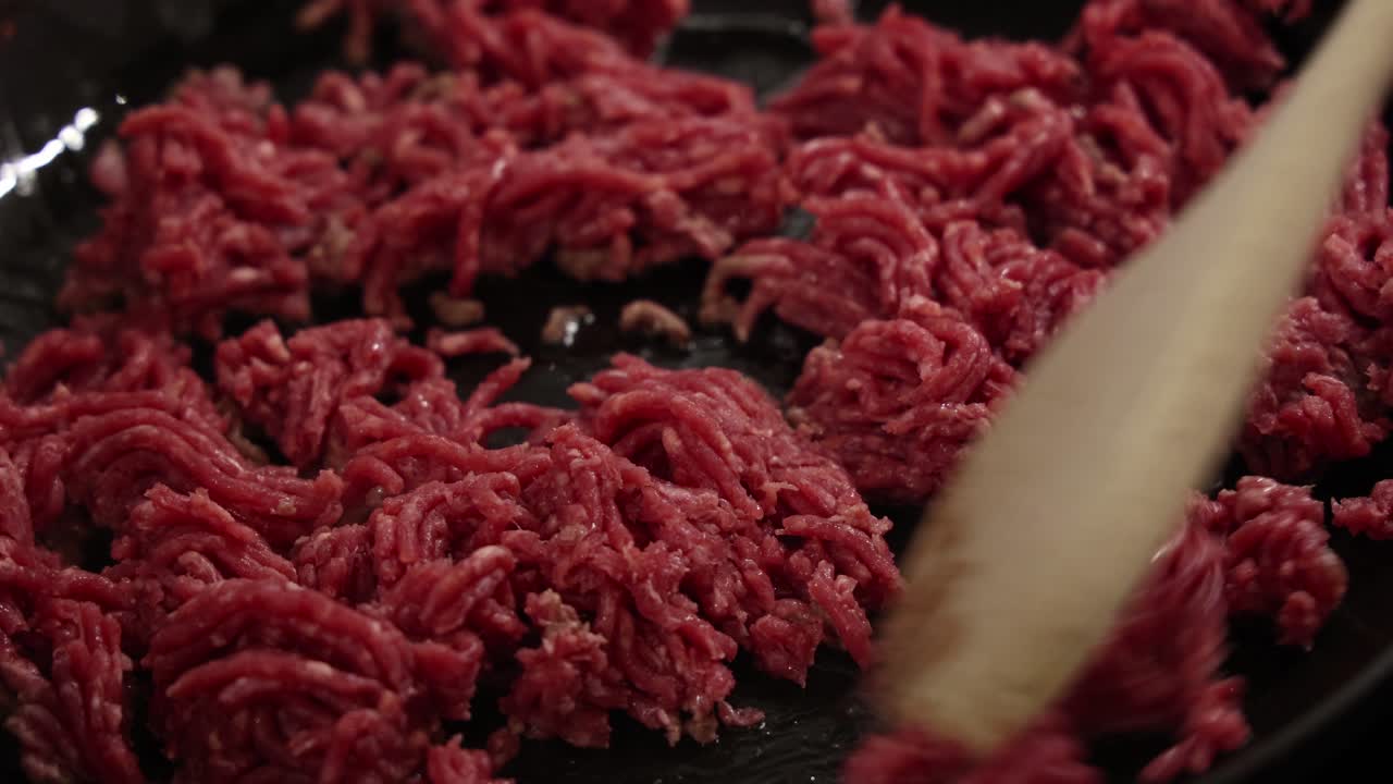 Rohes Hackfleisch wird in der Pfanne während der Kochvorbereitung in der Küche gerührt