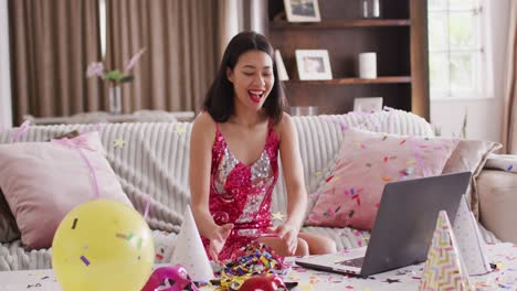 video of smiling biracial woman throwing confetti dressed in pink dress