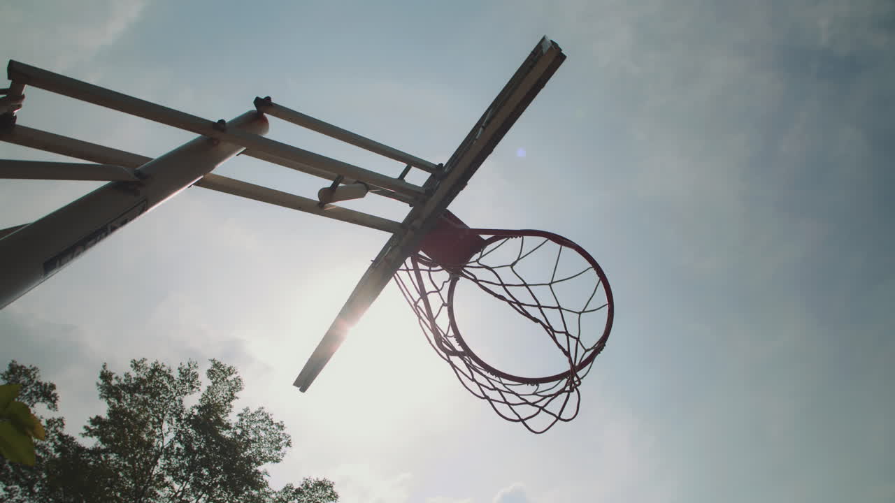 Streetball Hoop and Thrown Ball on Sunny Day outdoors