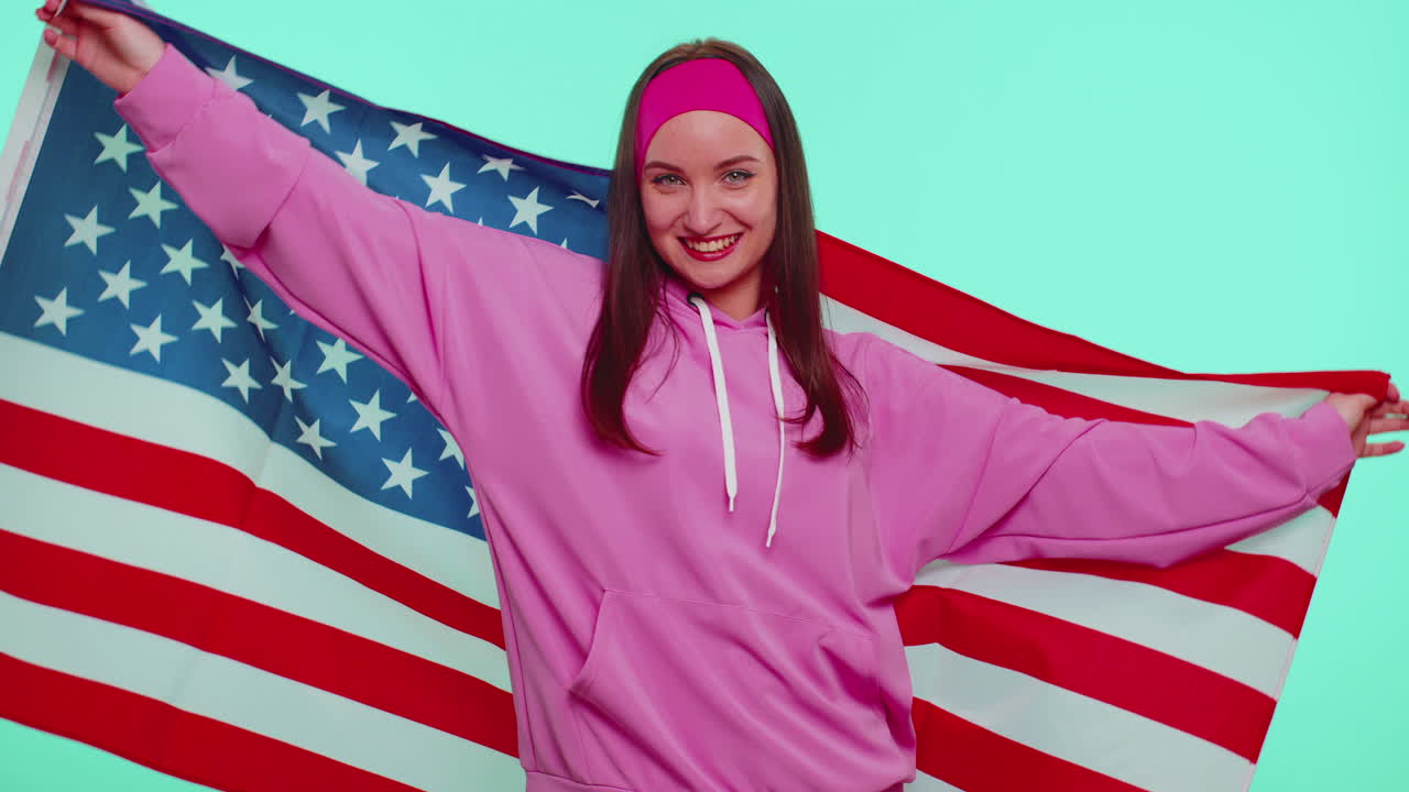 alegre adolescente agitando y envolviéndose en la bandera de los estados unidos de américa, celebrando los derechos humanos y las libertades