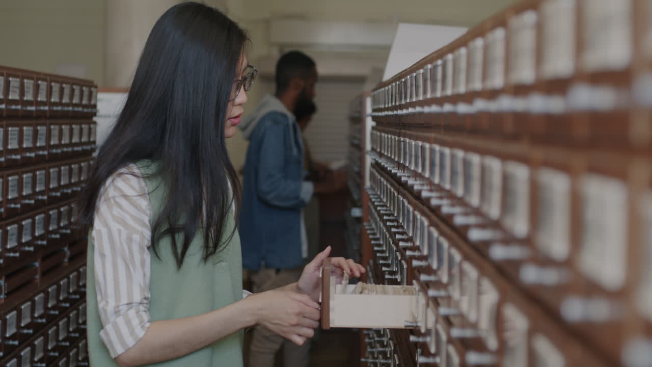 Woman Looking Through Documents in a Library Archive