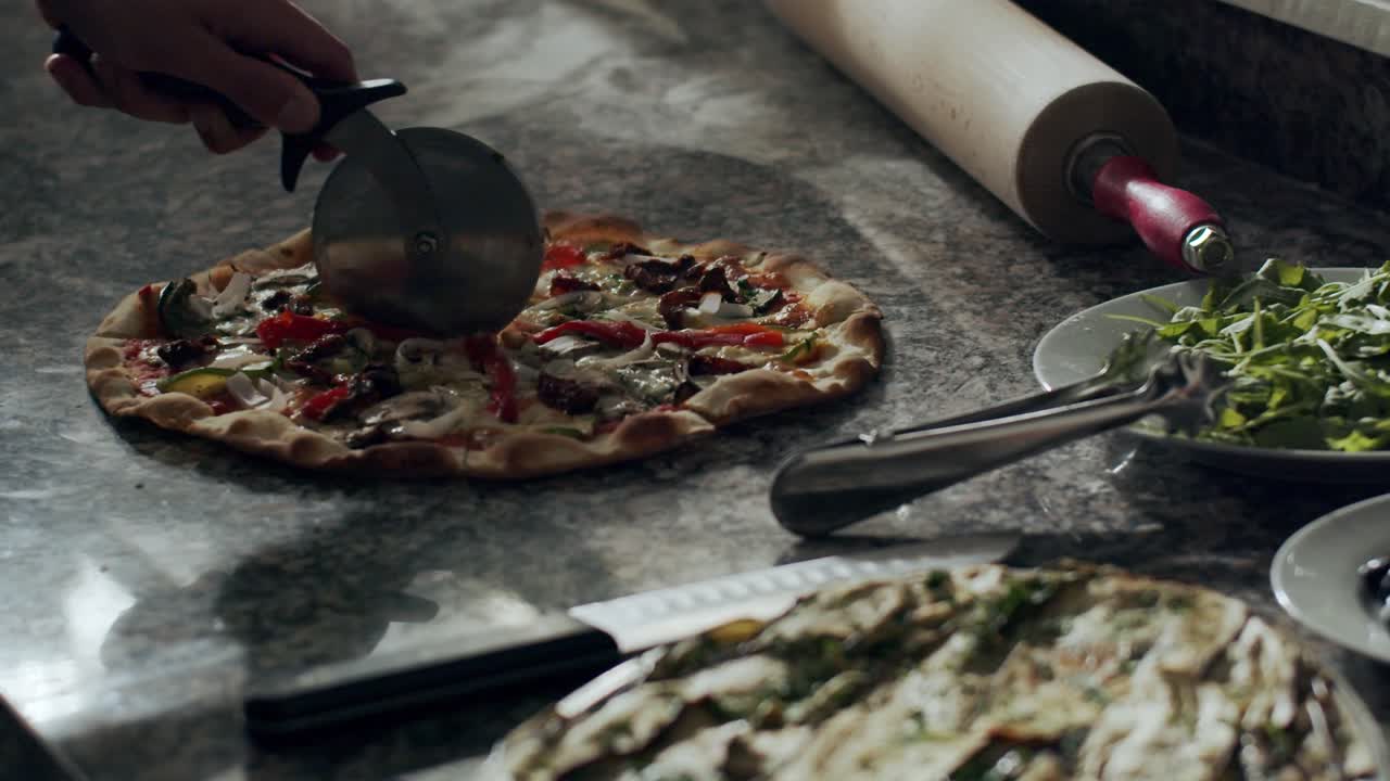 pizzaiolo cortando pizza fresca y caliente