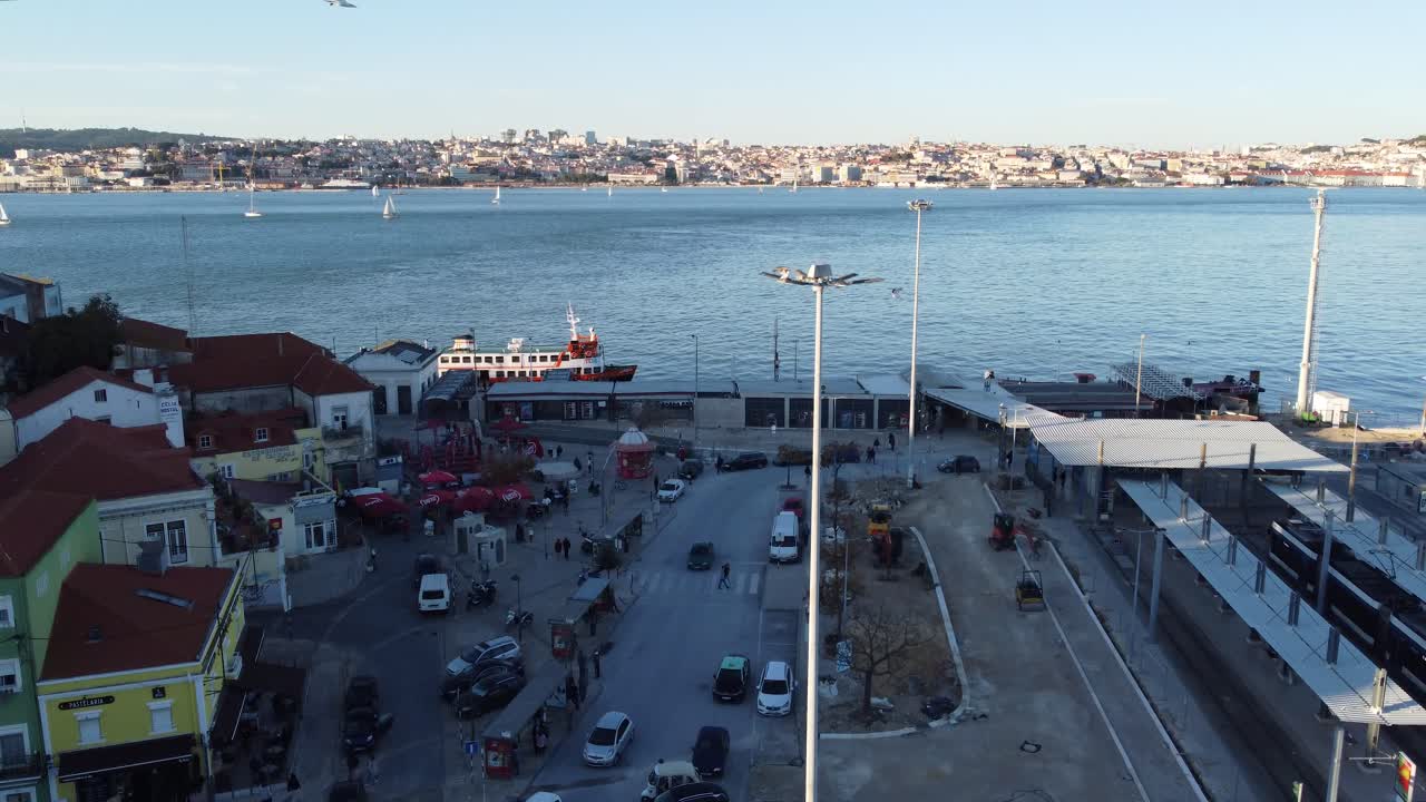 Drone shot flying over the river side Village of Cacilhas with a view of Lisbon on the other side of the River.