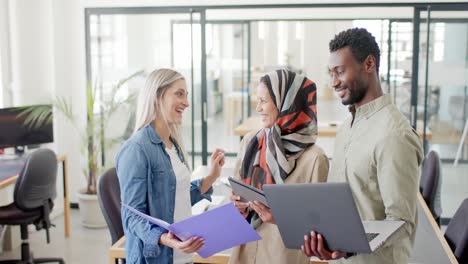 diversas personas de negocios felices discutiendo el trabajo con una computadora portátil en la oficina en cámara lenta
