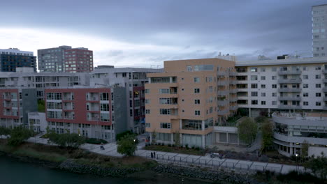 modern apartment buildings along an urban waterfront at dusk