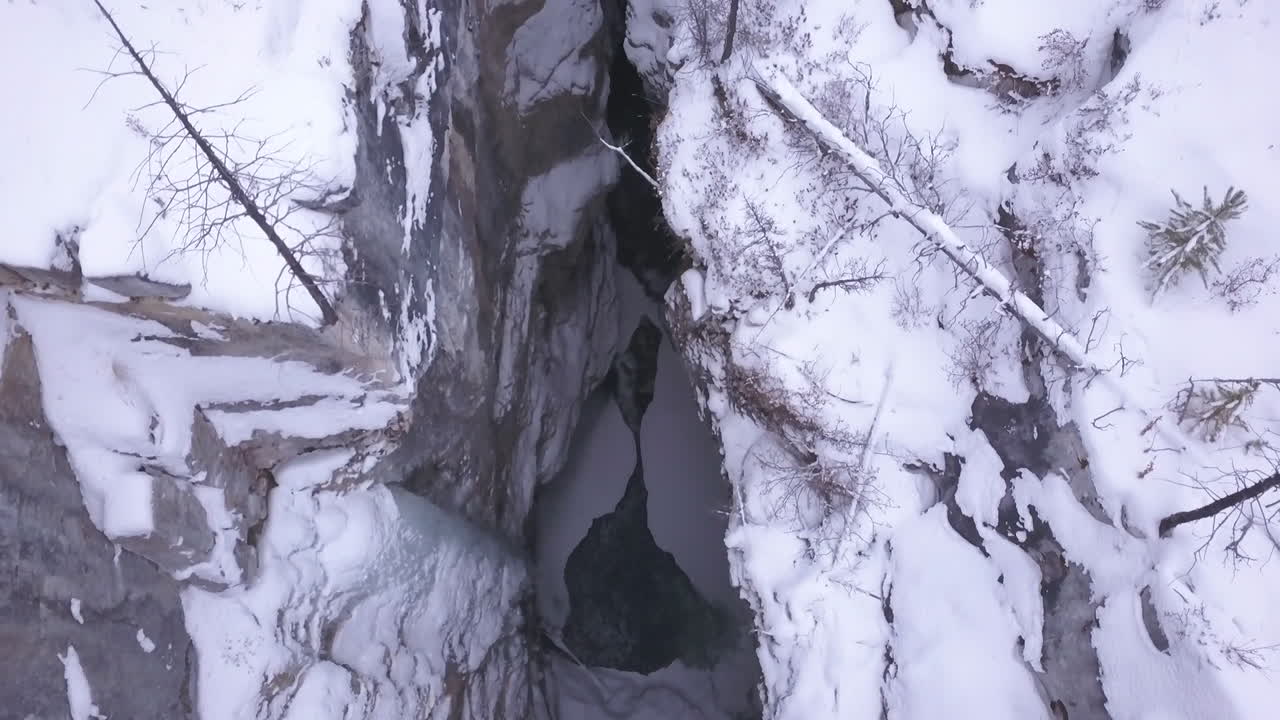 antena vertical del estrecho cañón del río de invierno con agua corriente debajo
