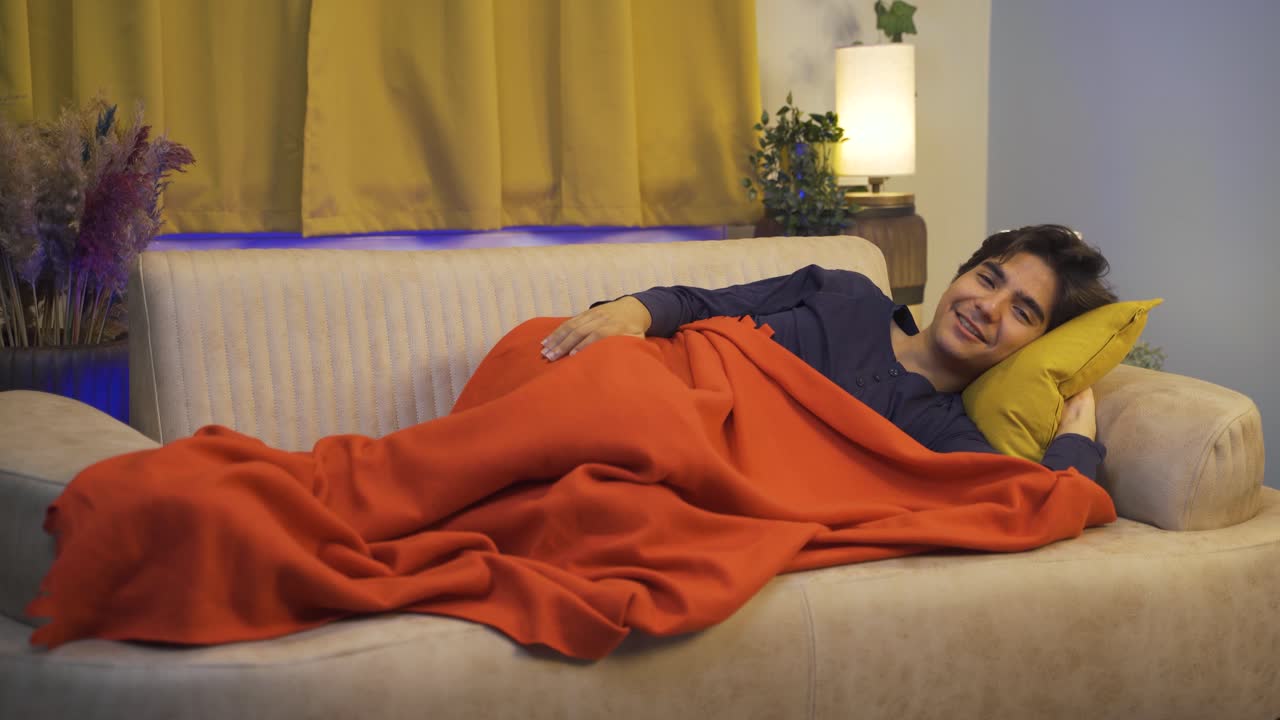 hombre en la cama riéndose de la cámara.