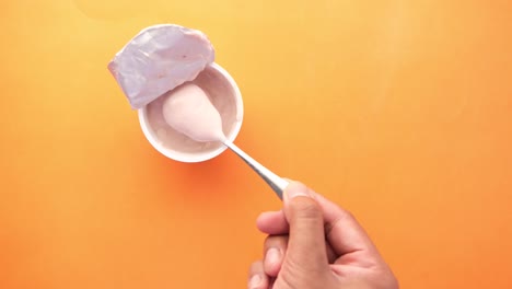 comiendo yogur con la mano de un recipiente