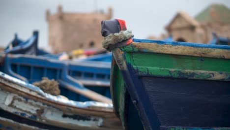 la cámara se desliza hacia la derecha, la proa del barco de pesca está enfocada y la fortaleza está desenfocada