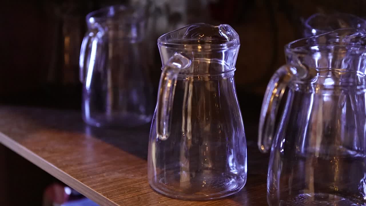 Handheld footage of a person picking up a glass pitcher in the bar