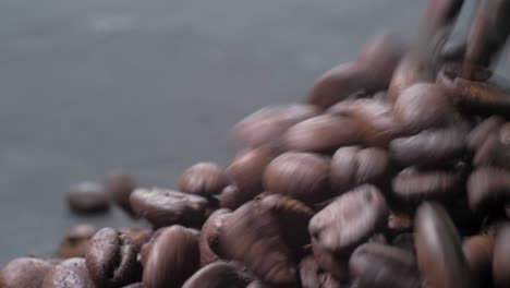 slow-motion footage of roasted ecuadorian coffee beans falling onto a gray table, a mesmerizing visual delight