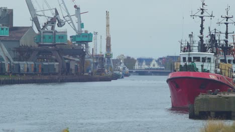 View-of-Port-of-Liepaja-with-port-cranes-and-moored-ships-on-overcast-day,-view-from-South-Pier,-distant-medium-shot