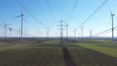 stream mast electricity with wind turbines in green meadows in summertime