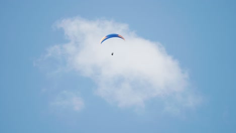 a lone paraglider soars through the skies on the parachute