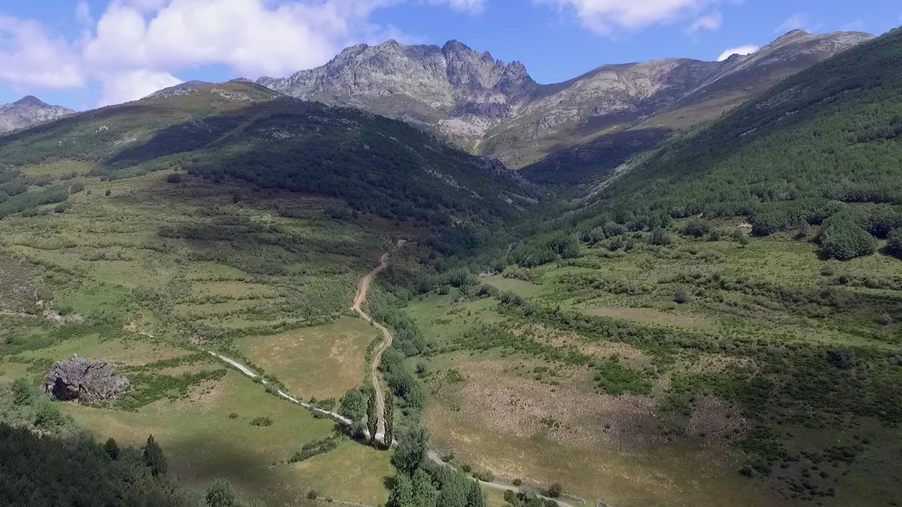 un valle con bosque y la montaña curavacas en el fondo