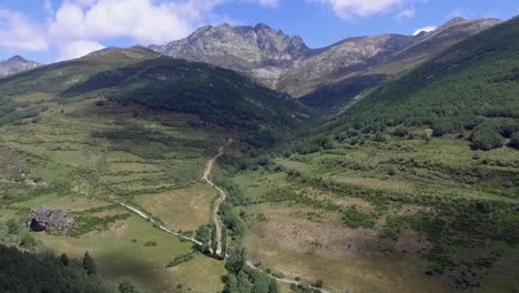 a valley with forest and the curavacas mountain in the background