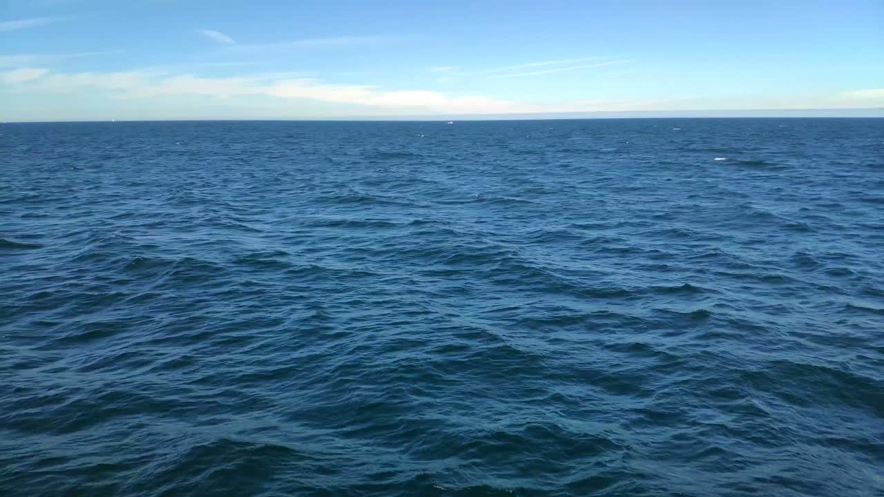 día soleado de cielo azul en las rías baixas, disparo viajando lateralmente a la izquierda, vista en primera persona navegando por la superficie del agua, el horizonte al fondo, pontevedra, galicia, españa