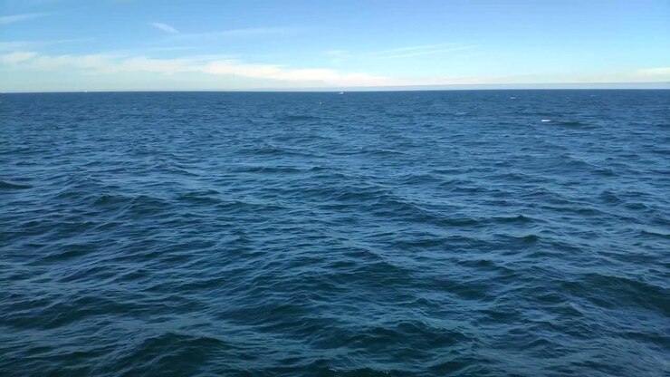 First-person view navigating the surface of the water, the horizon in the background, sunny day of blue sky in the Rías Baixas, shooting traveling laterally to the left, Pontevedra, Galicia, Spain