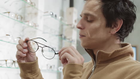 man trying on glasses in an optical store