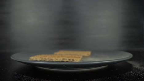 stack of rye crisbread falling on grey plate,close-up