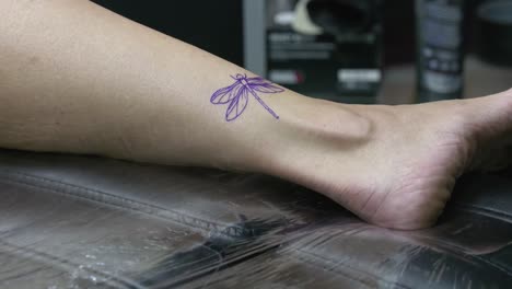 el dibujo para el tatuaje es cuidadosamente secado antes de que el tatuado pueda comenzar