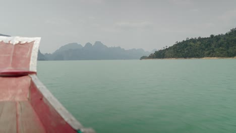 Scenic boat journey through a tranquil lake with islands and mountains